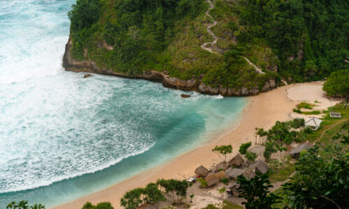 View of tropical beach, sea rocks and turquoise ocean, blue sky.